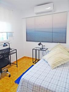 a bedroom with a bed and a desk and a window at Piso en Candelaria con terraza, vistas al mar, aire acondicionado y garaje in Candelaria