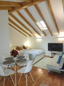 um quarto com uma cama, uma mesa e cadeiras em Charm studio em Bombarral