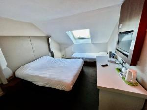 a small room with two beds and a television at Campanile Montargis - Amilly in Amilly