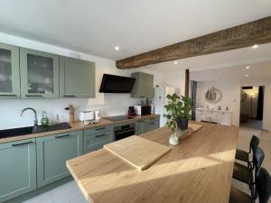 a kitchen with green cabinets and a wooden table at L'Authentique in Chablis