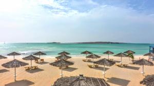 una spiaggia con ombrelloni e sedie e l'oceano di Luxury Penthouse on Square two a Sal Rei