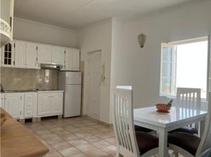 una cucina con tavolo bianco, tavolo, tavolo e finestra di Luxury Penthouse on Square two a Sal Rei