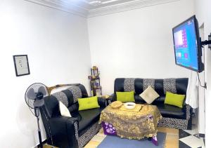 a living room with a black couch and a table at Apartment in Safi near the beach the sea calm down in Safi