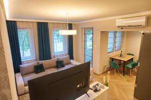 uma sala de estar com um sofá e uma televisão em Sunlight Silver Plus Szeged - Exclusive em Szeged