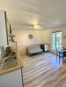 una cocina con fregadero y un sofá en una habitación en Camping maeva Respire Le Moulin de Surier, en Beaumont-du-Périgord