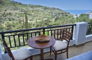a table and chairs on a balcony with a view at Loukas Apartments in Karavostamo