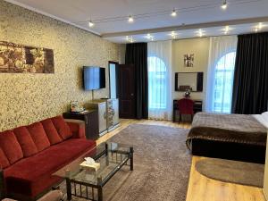 Habitación de hotel con sofá rojo y cama en Hotel Nika, en Chornomorsk