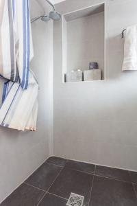 een badkamer met een handdoekenrek en een tegelvloer bij Appartement calme avec cachet (20 min de Paris) in Maisons-Laffitte