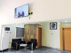 AbaにあるMOSANG HOTELS & SUITESの椅子と壁掛けテレビ付きの待合室