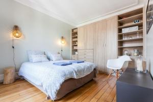 een slaapkamer met een bed, een bureau en een stoel bij Appartement calme avec cachet (20 min de Paris) in Maisons-Laffitte