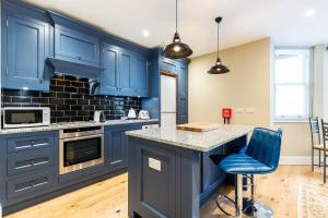 a kitchen with blue cabinets and a counter top at Colourful Studio Near Clapham Common! in London