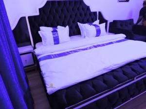 een slaapkamer met een groot bed en blauwe gordijnen bij MOSANG HOTELS & SUITES in Aba