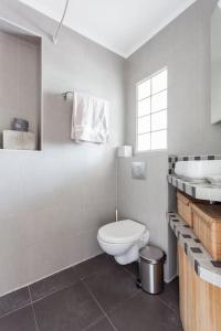 ein weißes Bad mit einem WC und einem Waschbecken in der Unterkunft Appartement calme avec cachet (20 min de Paris) in Maisons-Laffitte