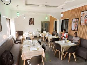 two men sitting in a restaurant with tables and chairs at MOSANG HOTELS & SUITES in Aba