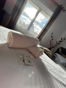 een handdoek bovenop een bed met een raam bij Vila Lion in Sebeş