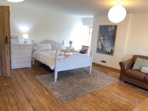 a bedroom with a white bed and a couch at Melin Tregib in Llandeilo