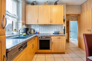 eine Küche mit Holzschränken und einem Waschbecken in der Unterkunft Münsterland Stadtlohn in Stadtlohn