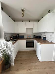 a kitchen with white cabinets and a potted plant at 288, Belle Aire, Hemsby - Beautifully presented two bed chalet, sleeps 5, pet friendly, close to beach! in Hemsby