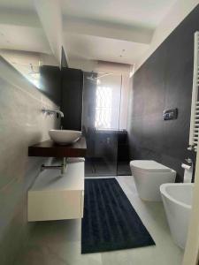 een badkamer met een wastafel, een toilet en een wastafel bij Casa vento marino in Livorno