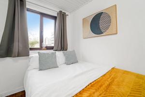 een slaapkamer met een wit bed en een raam bij BrightCentral Apartment With Parking in Glasgow