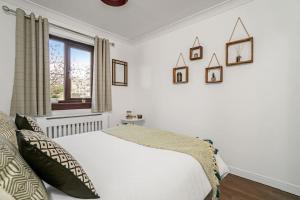 a white bedroom with a bed and a window at BrightCentral Apartment With Parking in Glasgow