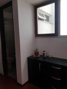uma casa de banho com uma cómoda preta e um espelho em Departamento pleno centro em Mar del Plata