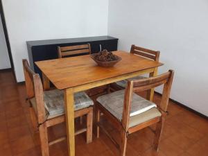 uma mesa de madeira com cadeiras e uma tigela de comida. em Departamento pleno centro em Mar del Plata