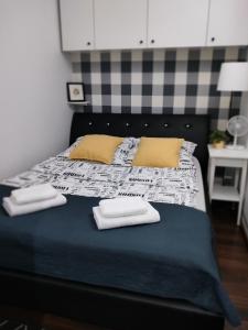 a bed with two towels on top of it at Apartament Baldachówka in Rzeszów