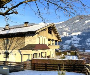 a house in the snow with a mountain in the background at 145m2Ferienwohnung Haas in Fügen