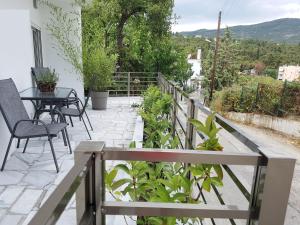 a patio with a table and chairs on a balcony at Panorama House* in Kavala