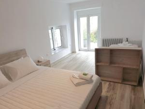 a white bedroom with a large bed and a bathroom at Panorama House* in Kavala