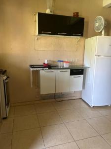 uma cozinha com um balcão e um frigorífico branco em Pousada Recanto do Zeca casa 3 na Praia Grande