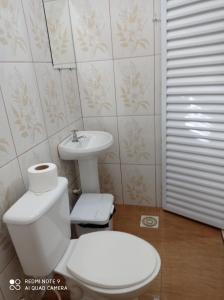 bagno con servizi igienici bianchi e lavandino di Pousada Recanto do Zeca casa 3 a Praia Grande