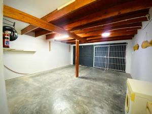 un garage vuoto con soffitti in legno e pavimenti in cemento di Beachfront 3 bedroom house a Hentiesbaai