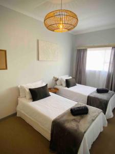 Habitación de hotel con 2 camas y lámpara de araña. en Beachfront 3 bedroom house, en Henties Bay