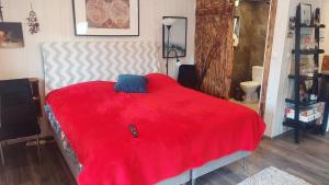 uma cama com um cobertor vermelho num quarto em DarWik Domki Letniskowe em Bukowo Morskie