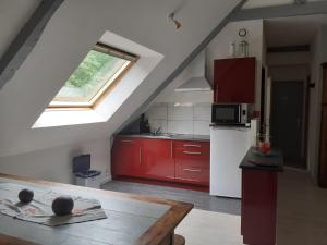 a kitchen with red cabinets and a white refrigerator at Gite à la ferme du chateau in Saint-Dolay