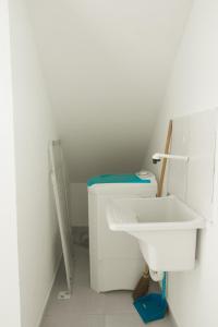 La salle de bains blanche est pourvue d'un lavabo et de toilettes. dans l'établissement Residencial Sales, à Guaibim