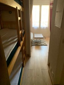 Zimmer mit einem Schlafzimmer mit Etagenbetten und einem Tisch in der Unterkunft Studio 5 couchages SCHUSS 5 la foux d’allos in Allos
