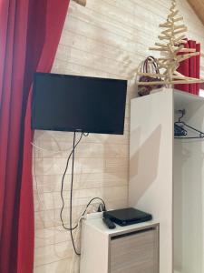 a television on top of a white cabinet in a room at La p'tite maison bois du hérisson in Ménétrux-en-Joux