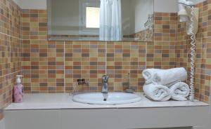 a bathroom with a sink and a mirror and towels at Aphrodite Studios in Kallithea Halkidikis +29 photos