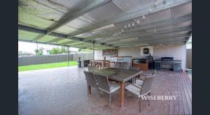 eine große Terrasse mit einem Tisch und Stühlen in der Unterkunft Luxurious and spacious home in taree in Taree