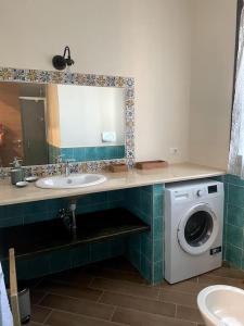 bagno con lavandino e lavatrice di Casa Pomelia a Mascali