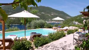 a swimming pool with lounge chairs and umbrellas at Amapola Boutique Villas with Sea Access - Phos in Sivota