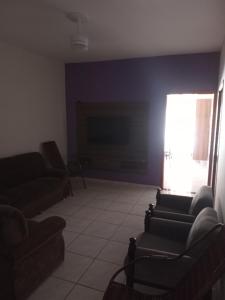 a living room with two couches and a tv at Recanto WL in Olímpia