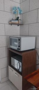 um micro-ondas sentado em cima de um armário em Apart ZSS em Penha