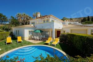 a villa with a swimming pool in front of a house at Jardim Secreto in Luz