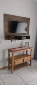 uma mesa de café em madeira com uma televisão na parede em Apart ZSS em Penha