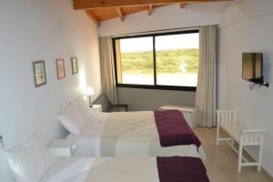 Un dormitorio con una cama grande y una ventana en Costanera Goya Apart & Hotel en Goya