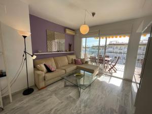 ein Wohnzimmer mit einem Sofa und einem Glastisch in der Unterkunft Cozy apartment in Costa del Sol in Mijas Costa